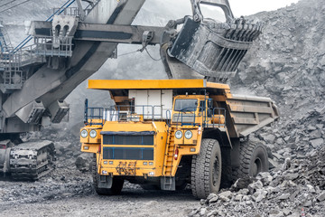 Powerful and large excavator bucket. Loading of minerals into the body of a mining truck. © nordroden