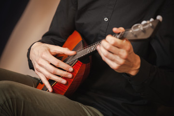 A man plays balalaika, close-up