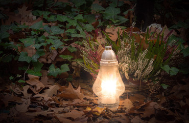 Luminous lantern at a grave in autumn time