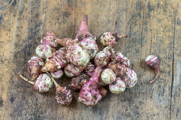 Jerusalem artichoke vegetables, isolated over white background with reflection. Helianthis tuberosus.