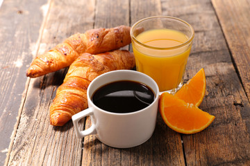coffee cup with croissant and orange