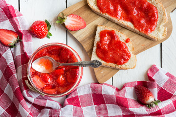 Homemade strawberry jam with fresh fruit on white