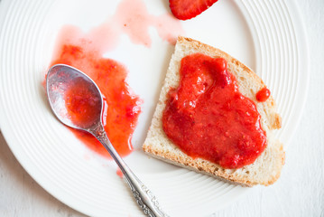 Homemade strawberry jam with fresh fruit on white