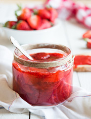Homemade strawberry jam with fresh fruit on white