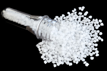 Polypropylene (PP) granules with blow injection molding bottle preform isolated on black...