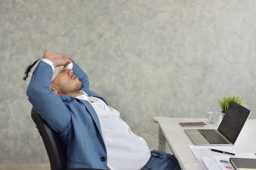 Young business men in suits are working Despite being unwell and injured his head at the table in...
