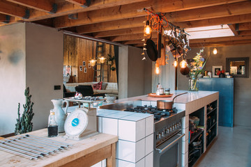 interior of cafe style professional kitchen with a view on a loft livingroom