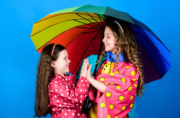 cheerful hipster children, sisterhood. rain protection. Rainbow. family bonds. Little girls in raincoat. happy little girls with colorful umbrella. autumn fashion. Carefree morning