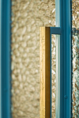 Brass doorhandles of steel pastel blue doors