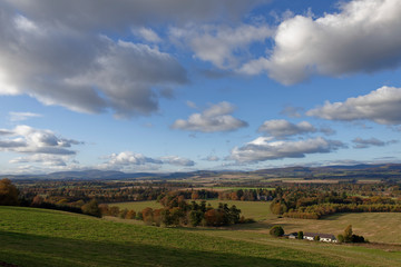 Obraz premium Looking towards Finavon Castle and the distant Angus Glens on a clear Octobers day, with a small white painted Farm Cottage on the Valley Floor.