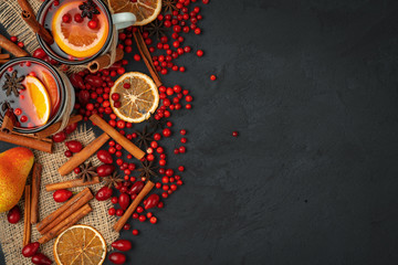 Top view of  hot mulled wine and spices on black background