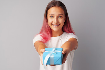 Nice teen girl holding gift box in her hands