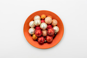 Christbaumkugeln auf einem roten Teller