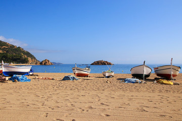 Costa Brava, fisher boats on the beach of the holiday destination Tossa de Mar, Catalonia - Spain