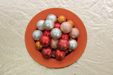 Christbaumkugeln auf einem roten Teller