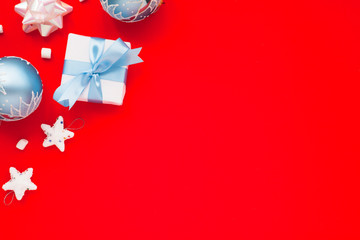 Christmas composition. Beautiful toys, gifts and candy on the red background. New year background. Top view. Close up. Space for a text.