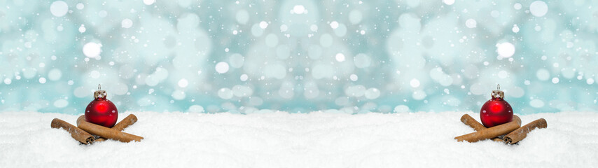 Fototapeta na wymiar Red baubles and cinnamon sticks on snow snowflakes - Christmas winter background banner long