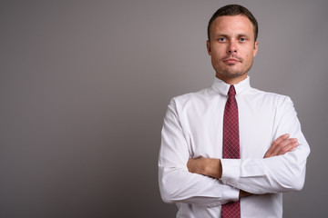 Portrait of handsome businessman against gray background