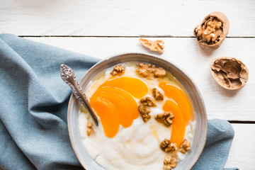 Yogurt with peach, nuts and honey in a bowl