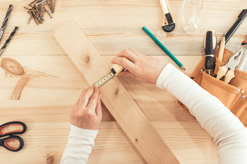 Top view of female carpenter hands working on desk