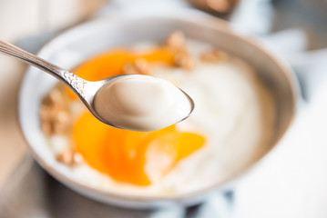 Yogurt with peach, nuts and honey in a bowl