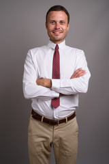 Portrait of handsome businessman against gray background