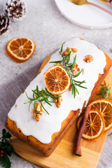 Obraz na płótnie Canvas Fruit cake dusted with icing, nuts and dry orange on stone background, flat lay. Christmas and Winter Holidays homemade cake