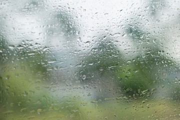 Abstract water drop pattern on glass mirror of train with blured green nature background after rainy day.Using as weather forecast background.Windshield.Rainy season.