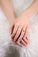 hands of a female on a soft white fake fur background
