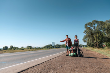 Hitchhiking couple. Backpackers on road
