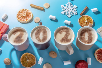 Card with numbers 2020 for New year and Christmas. Cup of coffee with figures on blue background. Top view. Flat lay