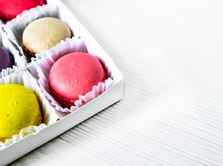 Macarons isolated on a white wooden background...