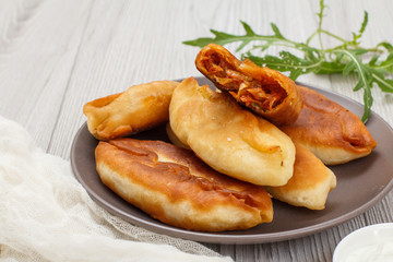 Plate with fried pies on wooden boards.