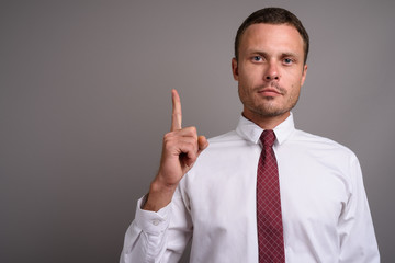 Portrait of handsome businessman against gray background