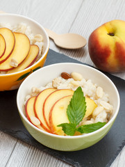 Sorghum salad with nuts and fresh peach on stone board.