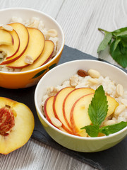 Sorghum salad with nuts and fresh peach on stone board.