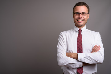 Portrait of handsome businessman against gray background