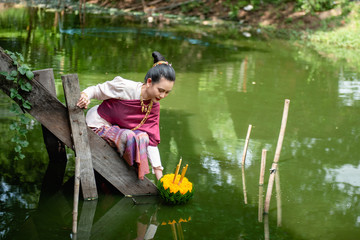 Beautiful woman ware Traditional Thai dresses hold floating basket or kratong, loy kratong festival in Thailand