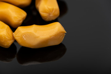 Pile of raw sausages isolated on black background with copy space text