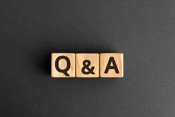 Q&A - acronym from wooden blocks with letters, questions and answers Q&A concept,  top view on grey background