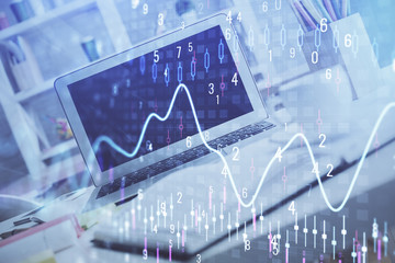 Stock market graph on background with desk and personal computer. Multi exposure. Concept of financial analysis.