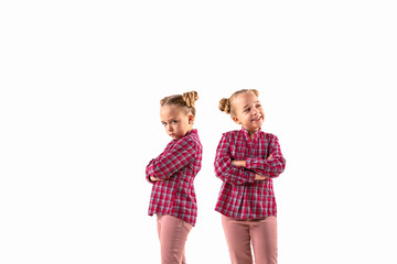 Young handsome girl arguing with herself on white studio background. Concept of human emotions, expression, mental issues, internal conflict, split personality. Half-length portrait. Negative space.