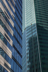 Obraz premium Сlimbers wash windows and glass facade of the skyscraper. Moscow city (Moscow International Business Center) , Russia