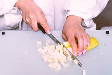 girl cuts with a knife leek