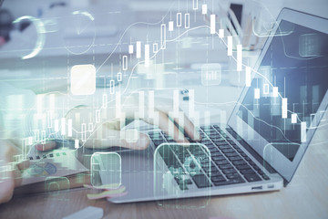 Multi exposure of stock market graph with man working on laptop on background. Concept of financial analysis.