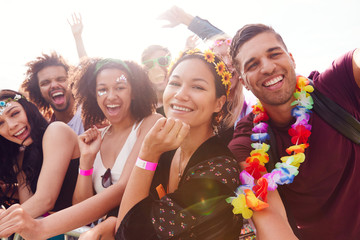 Portrait Of Young Friends In Audience Behind Barrier At Outdoor Music Festival