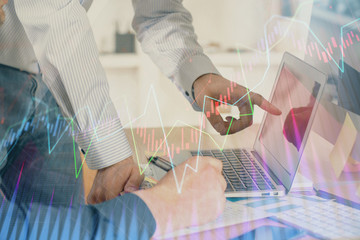 Double exposure of chart with businessman typing on computer in office on background. Concept of...