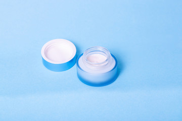 blue jar with cream on blue background