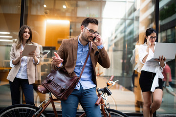Young business people outdoors working, brainstorming. Technology concept