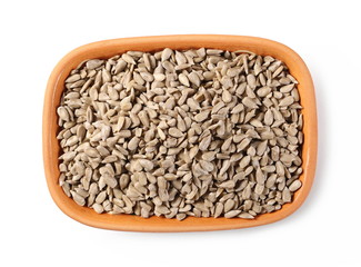 Peeled sunflower seeds in clay bowl isolated on white background